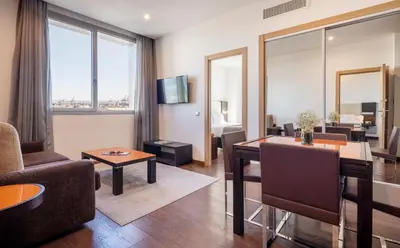 a living room with a table and a dining room at Ilunion Aqua 4 in Valencia