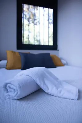 a white blanket laying on a bed with a window at Patacona by Concept Flats in Valencia