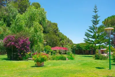 a park with flowers and a lamp in the grass at Villa Montgrau in Llano de Gorra