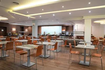 a restaurant with tables and chairs in a room at Port Feria Valencia in Valencia