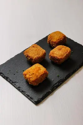 a pastry with an orange fruit on a black plate at Port Feria Valencia in Valencia