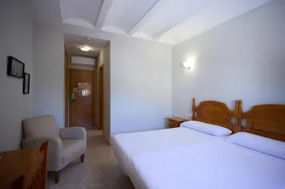 a hotel room with a bed and a chair at Hotel De Jerica in Jérica