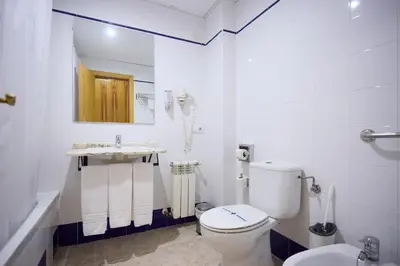 a white bathroom with a toilet and a sink at Hotel De Jerica in Jérica
