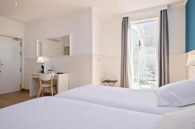a white bedroom with a bed and a desk and a window at Venecia Plaza Centro in Valencia