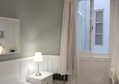 a bedroom with a bed and a window and a lamp at Venecia Plaza Centro in Valencia