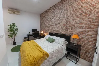 a bedroom with a brick wall and a bed with a yellow blanket at Digital Nomad Retreat 2 -Great Location Near Metro in Valencia