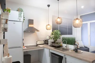 a kitchen with white cabinets and a sink and pendant lights at Artistic Digital Retreat-Great Location Near Metro in Valencia