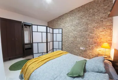 a bedroom with a bed and a brick wall at Artistic Digital Retreat-Great Location Near Metro in Valencia