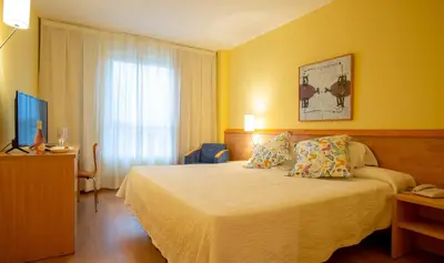 a hotel room with a bed and a television at Flag Hotel Valencia in Masalfasar