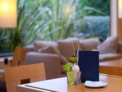 a table with a book and a vase with a plant at Flag Hotel Valencia in Masalfasar