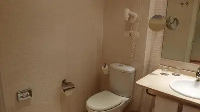 a bathroom with a toilet and a sink at Flag Hotel Valencia in Masalfasar