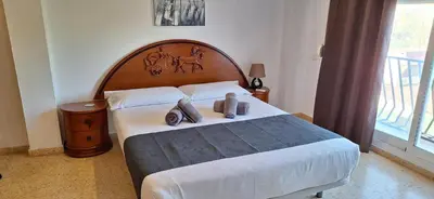 a bedroom with a large bed with a wooden headboard at Gracioso apartamento en Massanassa in Benetúser
