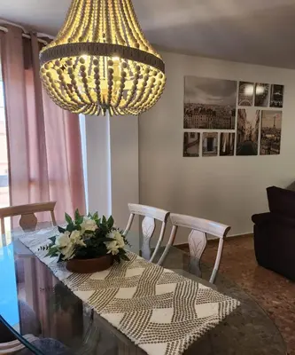 a large chandelier hanging over a dining room table at Magnifico apartamento en Burriana in Burriana
