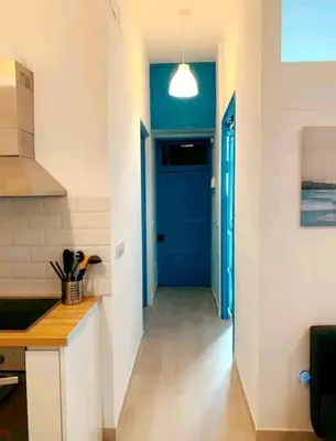 a hallway of a kitchen with a blue door at Apartamento en la playa las arenas +Wifi+AC in Valencia