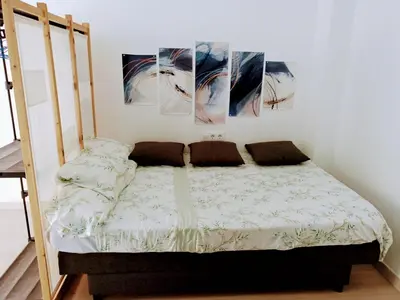 a bed in a room with three paintings on the wall at Apartamento en la playa las arenas +Wifi+AC in Valencia