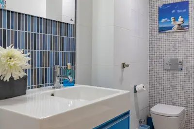 a white bathroom with a sink and a toilet at ApartUP Patacona Azzure in Valencia