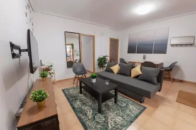 a living room with a couch and a table at Artsy Large Getaway - 2 Bedroom w HUGE patio - Great for families and Digital Nomads in Valencia