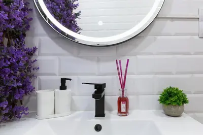 a bathroom with a sink with a mirror and purple flowers at Artsy Large Getaway - 2 Bedroom w HUGE patio - Great for families and Digital Nomads in Valencia