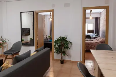 a living room with a couch and a dining room at Artsy Large Getaway - 2 Bedroom w HUGE patio - Great for families and Digital Nomads in Valencia