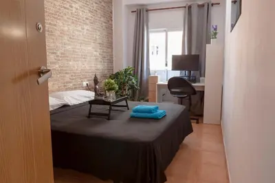 a bedroom with a bed with a table and a desk at Artsy Large Getaway - 2 Bedroom w HUGE patio - Great for families and Digital Nomads in Valencia