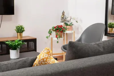 a living room with two couches and potted plants at Artsy Large Getaway - 2 Bedroom w HUGE patio - Great for families and Digital Nomads in Valencia