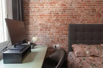 a desk with a computer on it next to a brick wall at Artsy Large Getaway - 2 Bedroom w HUGE patio - Great for families and Digital Nomads in Valencia