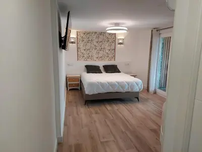 a bedroom with a bed and a wooden floor at Hostal GARDEN ROUS in Paiporta