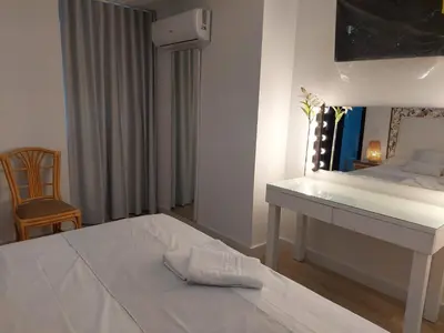 a bedroom with a white bed and a desk at Hostal GARDEN ROUS in Paiporta
