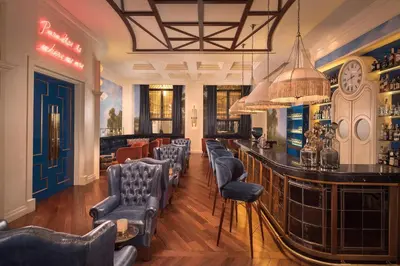 a bar with blue chairs and a bar counter at The Westin Valencia in Valencia