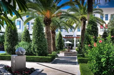 a courtyard with palm trees and a building at The Westin Valencia in Valencia