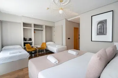 a hotel room with two beds and a table at YOU & CO. J. Botánico Boutique in Valencia