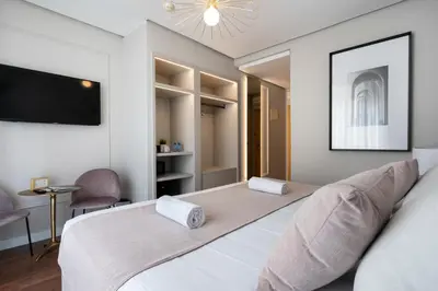a bedroom with two beds and a flat screen tv at YOU & CO. J. Botánico Boutique in Valencia