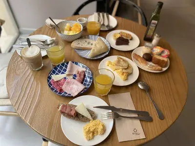 a wooden table with plates of breakfast food on it at YOU & CO. J. Botánico Boutique in Valencia