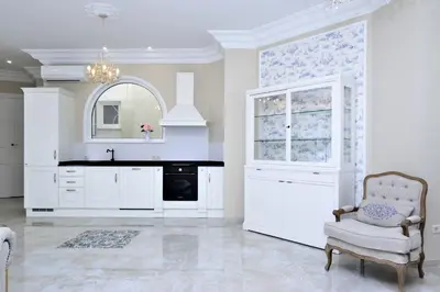 a kitchen with white cabinets and a chair and a mirror at Joaquín Sorolla in Valencia