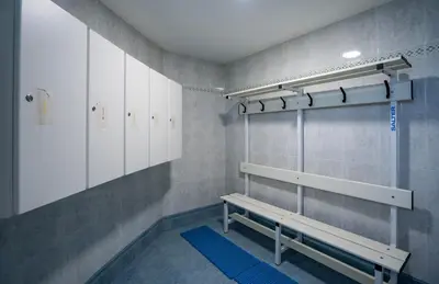 a locker room with a bench and white cabinets at Hotel Bartos in Almussafes