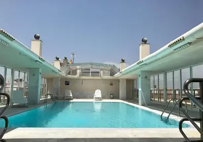 a swimming pool on the roof of a building at Hotel Bartos in Almussafes