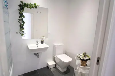a bathroom with a toilet and a sink and a mirror at Hogar moderno cerca de Casco Antiguo de Valencia in Valencia