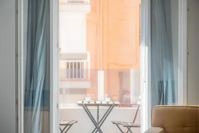 a room with a window with a table and a chair at Modern, Stylish Apartment with balcony in Valencia