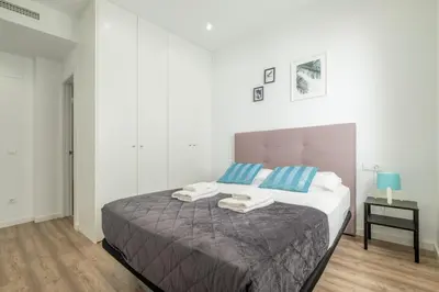 a bedroom with a large bed with blue and white pillows at Modern, Stylish Apartment with balcony in Valencia