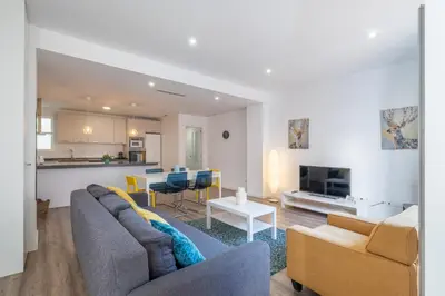 a living room with a couch and a table with chairs at Modern, Stylish Apartment with balcony in Valencia