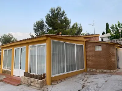a house with large glass windows on the side of it at Encantador alojamiento con acceso a piscina compartida in Monserrat
