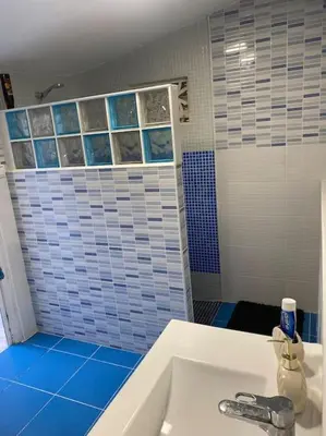 a bathroom with a white sink and blue tiles at Encantador alojamiento con acceso a piscina compartida in Monserrat