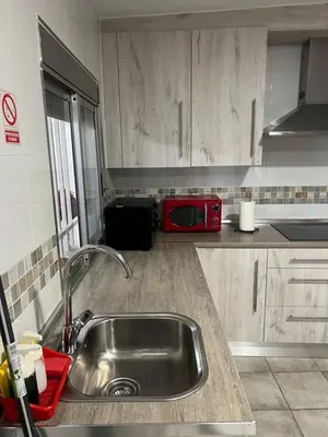a kitchen with a sink and a red microwave at Encantador alojamiento con acceso a piscina compartida in Monserrat