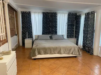 a bedroom with a large bed with blue curtains at Encantador alojamiento con acceso a piscina compartida in Monserrat