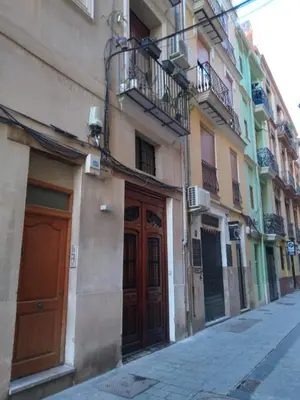 a row of buildings with wooden doors on a street at Your Valencia Home in Valencia