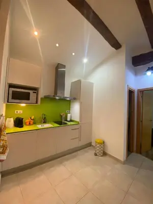 a kitchen with white cabinets and green walls at Your Valencia Home in Valencia