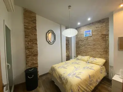 a bedroom with a bed and a brick wall at Your Valencia Home in Valencia