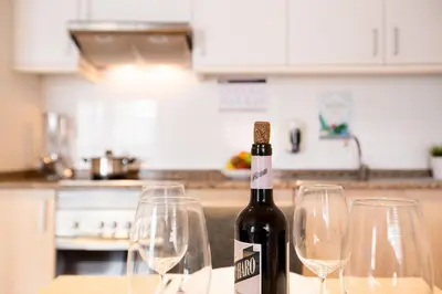 a bottle of wine sitting on a table with wine glasses at Valenciaflats Ciudad de las Ciencias in Valencia