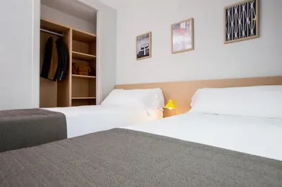 two beds in a hotel room with white sheets at Valenciaflats Ciudad de las Ciencias in Valencia