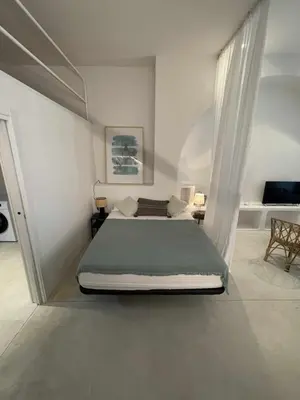 a bedroom with a large bed in a white room at Maravilloso Loft junto a Ciudad de Artes y Ciencia in Valencia